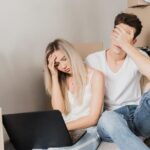 Gestrest stel zit tussen verhuisdozen tijdens voorbereiding op woningontruiming Hilversum