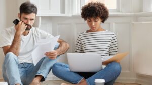 Koppel bekijkt serieuze documenten en zoekt online hulp bij woningontruiming Hilversum