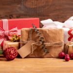 Luxe decembercadeaus met feestelijke verpakkingen in rood, goud en kraftpapier, omringd door kerstdecoratie.