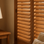 Houten shutters filteren zacht daglicht in een warme, rustgevende woonkamer met natuurlijke inrichting