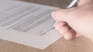 Hand zet handtekening onder een shortleasecontract voor tijdelijk gebruik van een auto