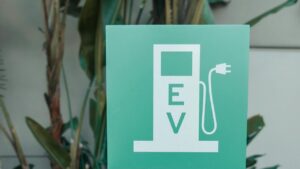 Symbool van een laadpunt aan huis voor elektrische voertuigen op een groen bord met stekkerpictogram
