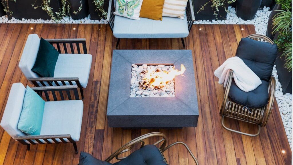 Modern hardhouten terras met vuurtafel, comfortabele zitmeubels en decoratieve planten