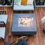 Modern hardhouten terras met vuurtafel, comfortabele zitmeubels en decoratieve planten