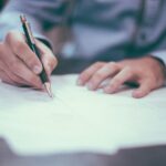 Man tekent juridische documenten aan bureau als onderdeel van helder juridisch advies